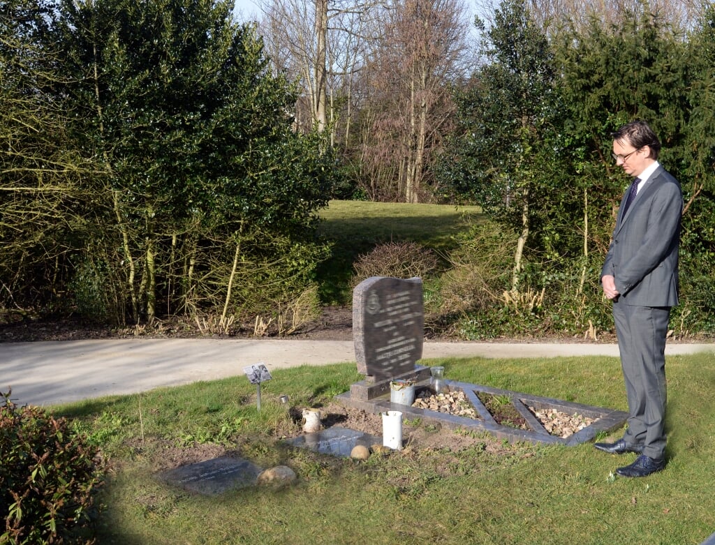Burgemeester Uitdehaag toont zijn eerbied bij één van de graven.