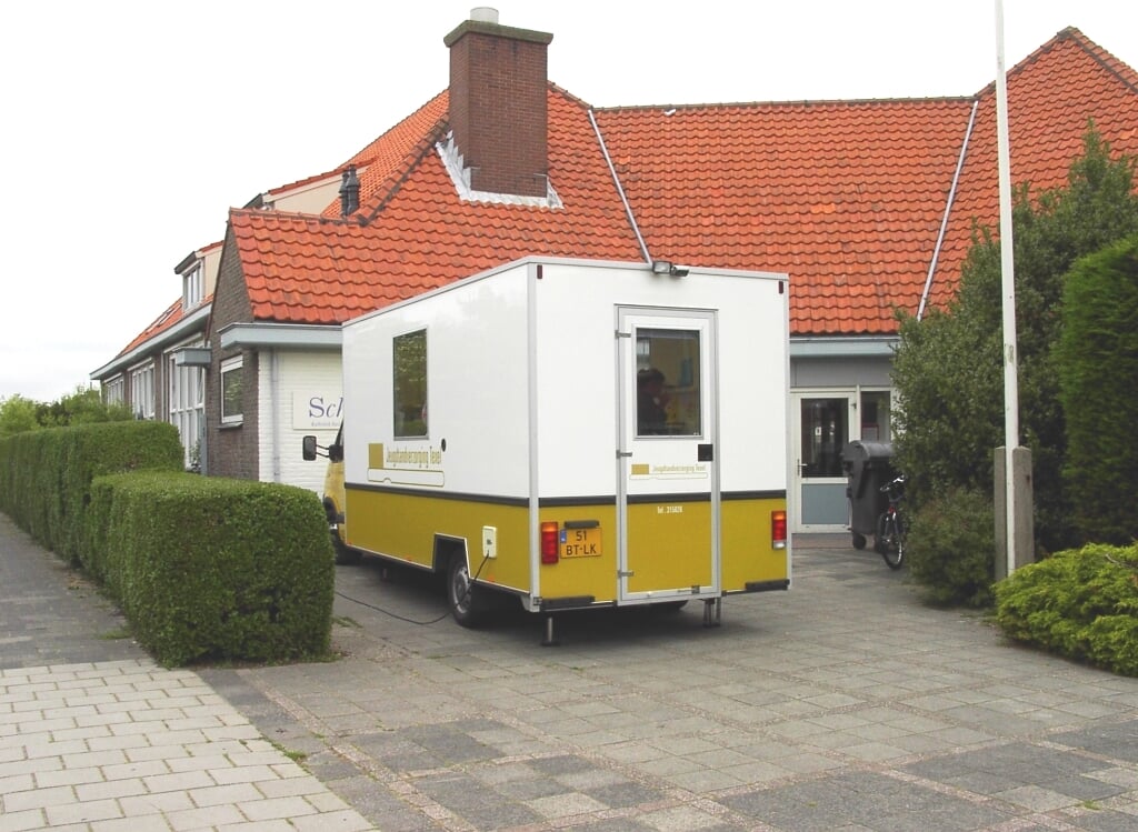 De dental car van de Stichting Jeugdtandverzorging bij de Jozefschool in Den Burg.