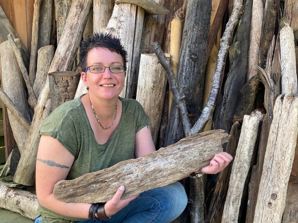 Annemieke Kuiper met bij een stapel oud hout waarvan ze bijzondere dingen maakt. Onder een impressie uit haar winkel, die ze met Linda den Braven runt. 