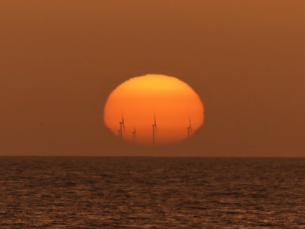 De windmolens bij de Afsluitdijk, in de vroege ochtend gezien vanaf De Cocksdorp bij een opkomende zon. Foto Henk Leyen