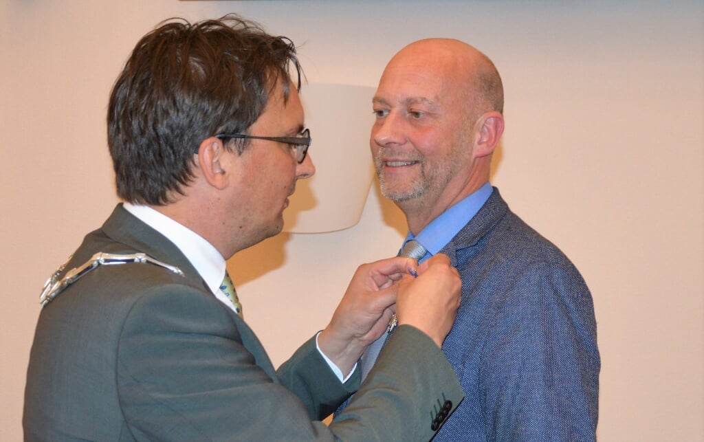 Peter van Sijp krijgt de onderscheiding opgespeld.