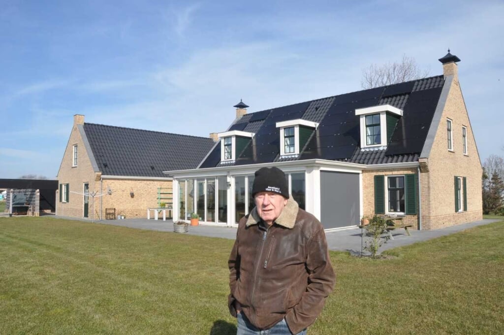 Nan Molenaar met zijn nieuwe woning die volledig in de eigen energiebehoefte voorziet. 