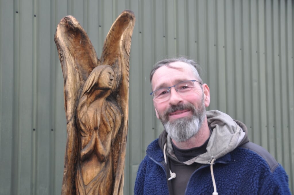 Gert van Klaveren met een houten engel die hij een paar jaar geleden met de hand maakte (en die momenteel in onderhoud is).
