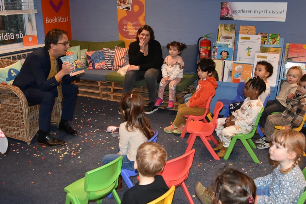 De burgemeester voorlezend aan kinderen.