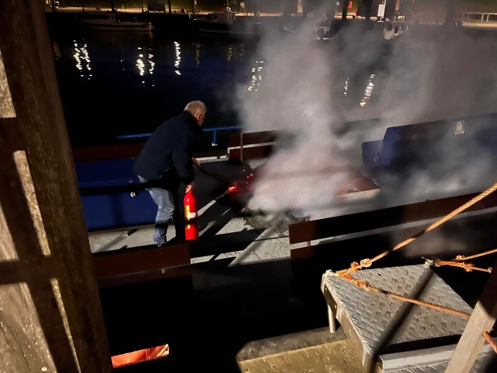 Jaap Tuitman bestrijdt het vuur aan dek van de Rival met een brandblusser.