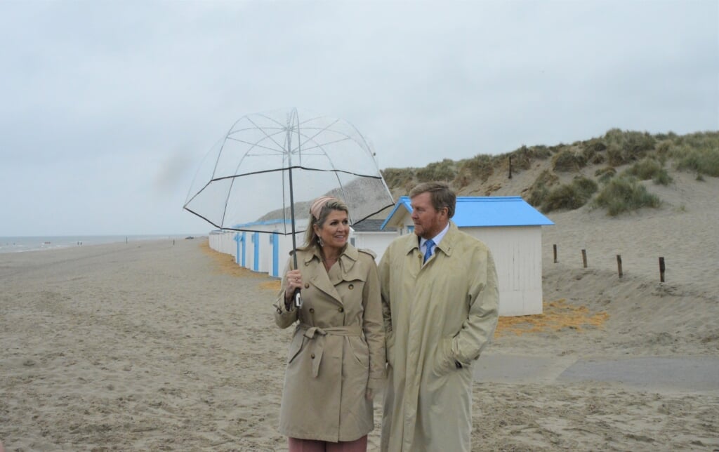 Máxima en Willem-Alexander nemen bij paal 9 een kijkje op het strand. 