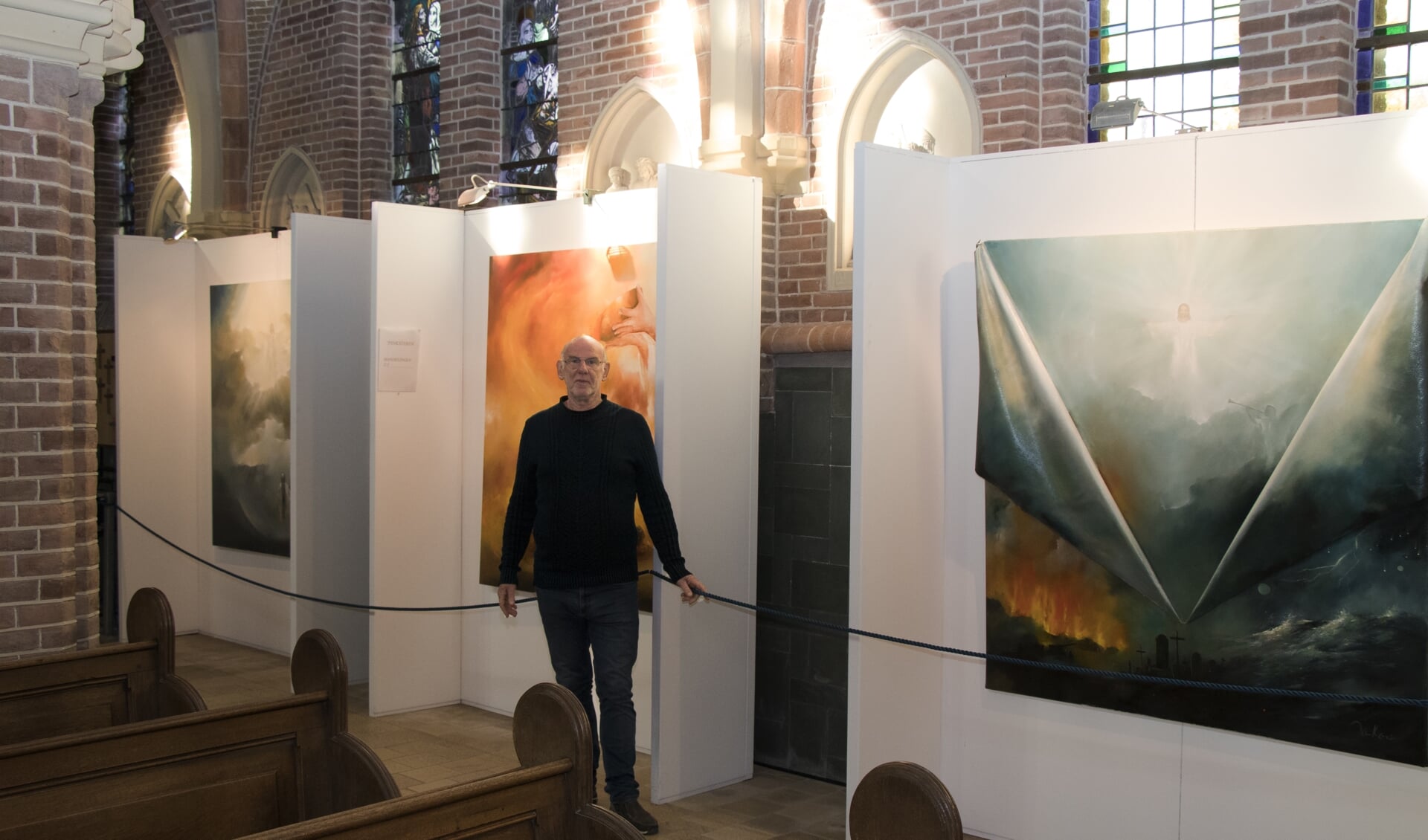 Jan Kooistra in 2018 in de Bonifatius kerk in Dokkum bij schilderijen uit de serie In verwondering: het leven van Jezus.