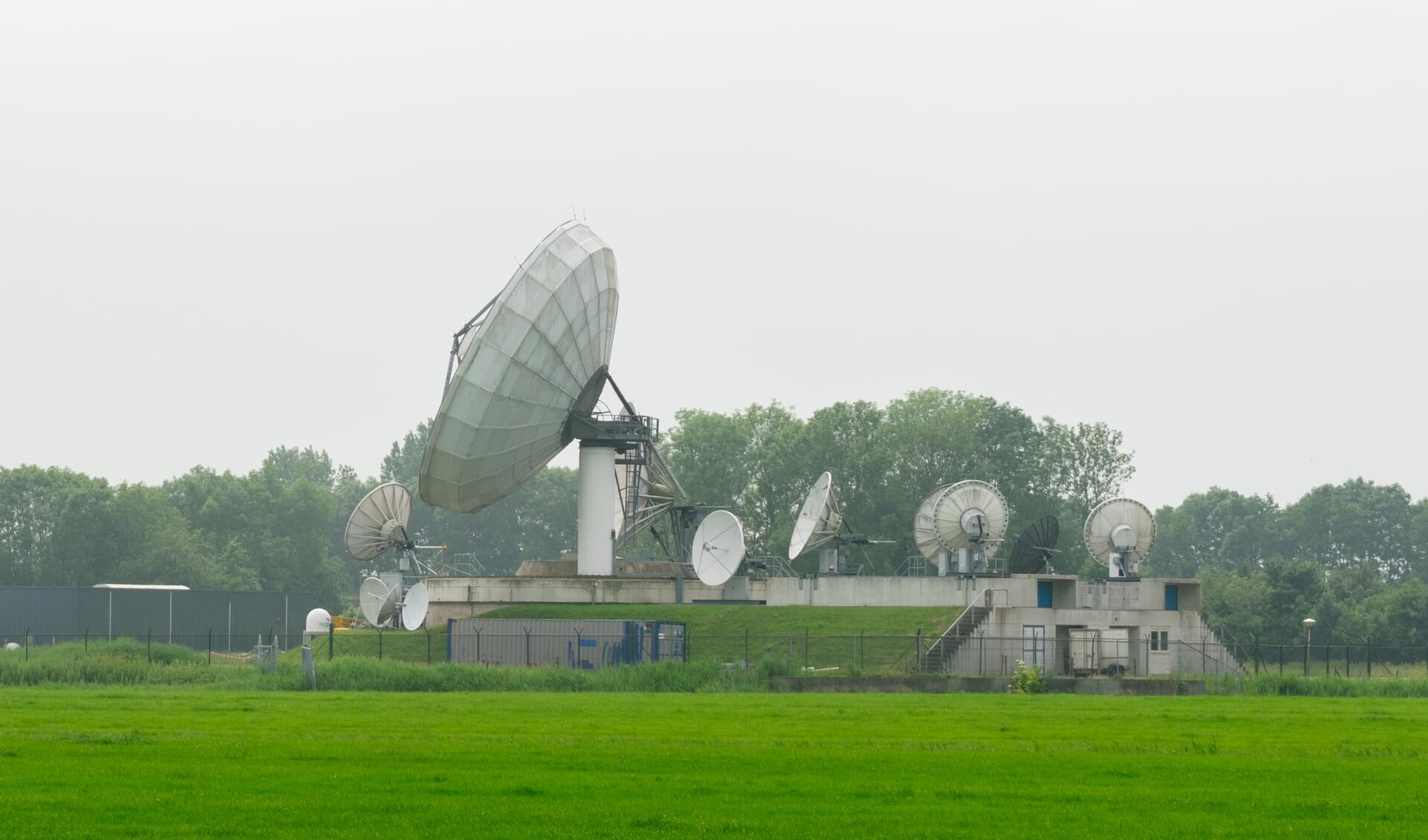 In een weiland naast de satellietschotels speelt Eline de Vries de voorstelling 'De grutte earen'.