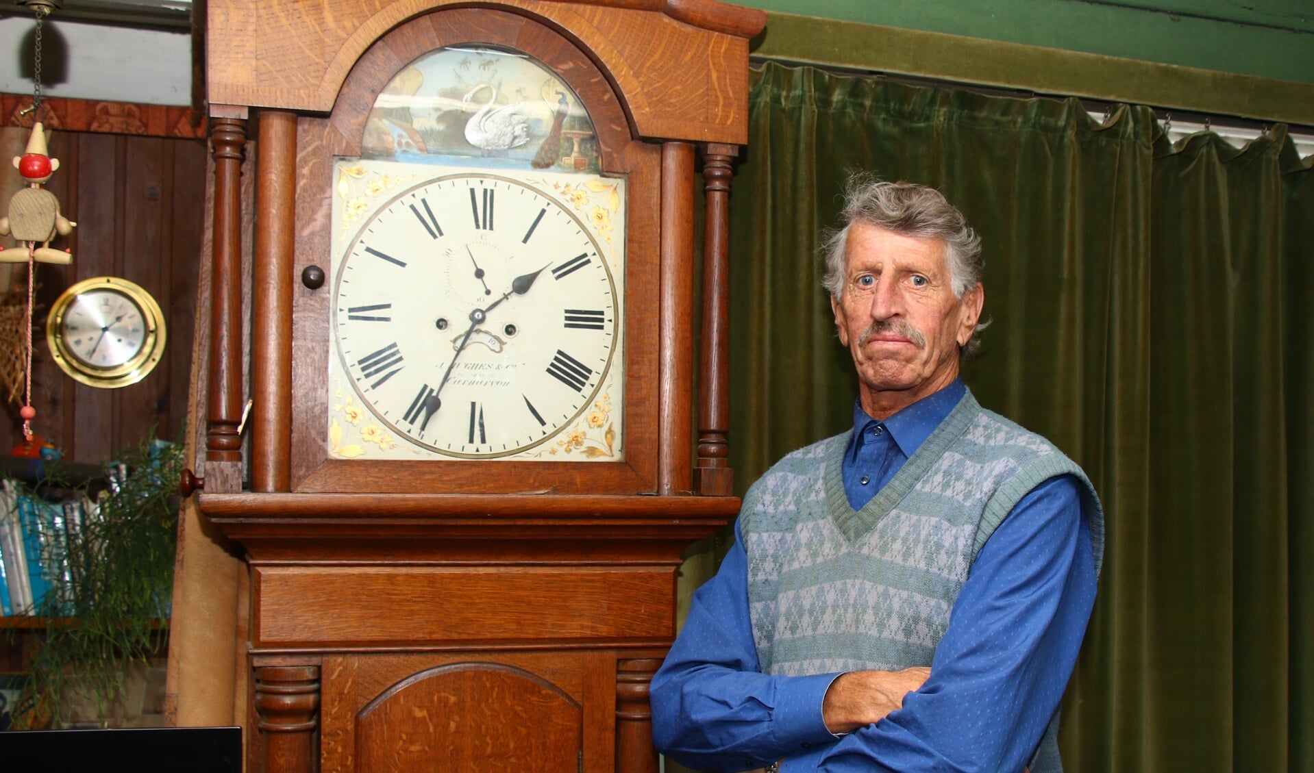 Lou Kuipers bij een klok in zijn woonkamer, boven de klokkenmakerij. 