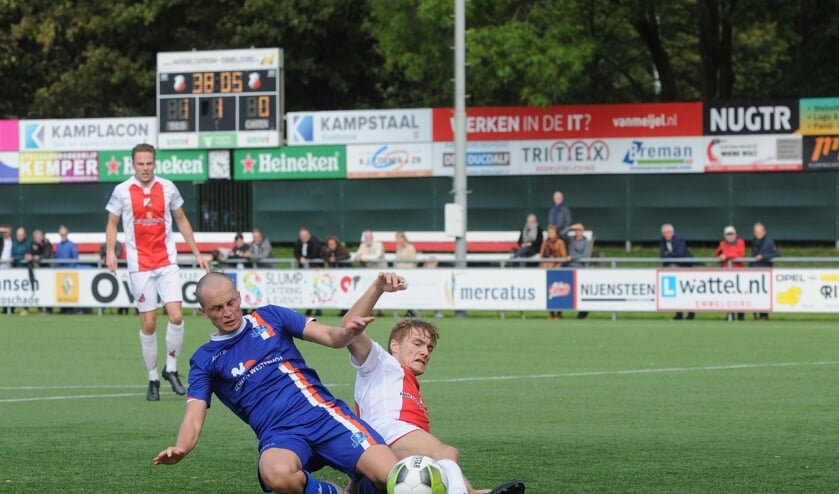 Jorrit Terpstra van Buitenpost (blauw shirt) verwikkeld in een fel duel.
