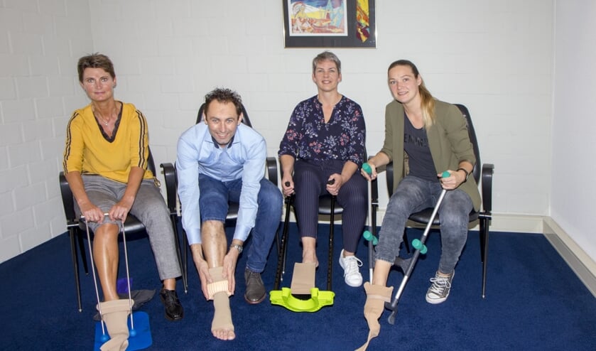 De compressietherapeuten Sjieuwke van der Bij, Klaas Helfrich, Jannie Vaatstra en Janet Spoelstra tonen vier verschillende aantrekhulpen.