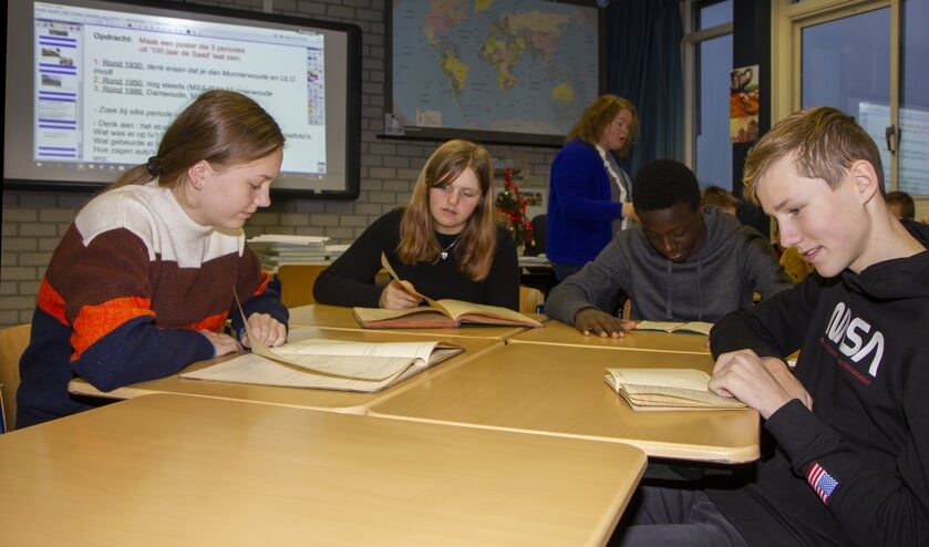 Lisa, Rebecca, Méthode en Mika bekijken tijdens de geschiedenisles archiefstukken van De Saad. De school bestaat 100 jaar. Vrijdag is er een ceremonie. Voor de leerlingen zijn er later dit jaar activiteiten. Bekijk de les met je app.