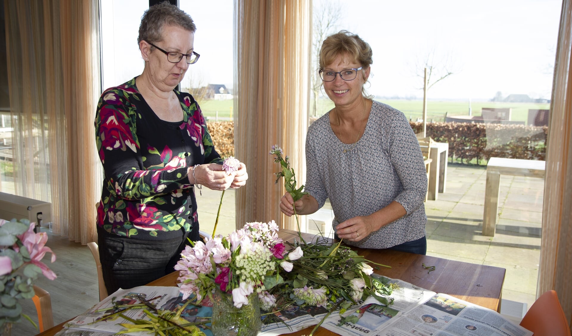 Een bewoner en medewerker van Herbergier Bartlehiem maken er een leuke middag van door samen te bloemschikken.