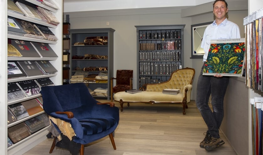 Rienk Kooistra in de vernieuwde winkel van Meubelstoffeerderij Dokkum. Er is keus uit honderden meubelstoffen. Pluchen tafelkleden vindt men hier ook nog.