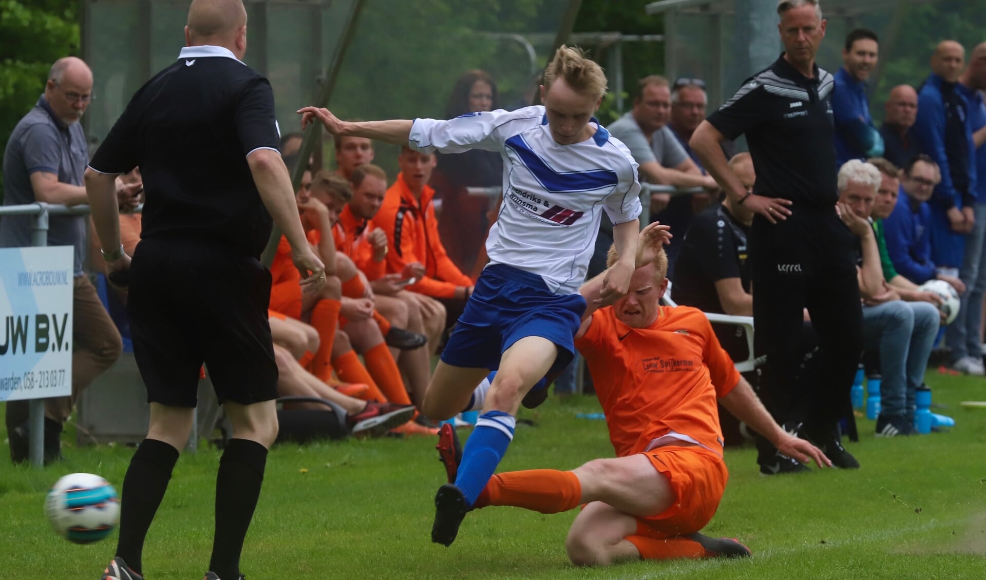 Yannick Hoekstra van Kollum (oranje tenue) probeert Jorn Geert Kramer van Rijperkerk het spelen te beletten.