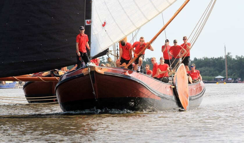 Het skûtsje van Earnewâld met schipper Gerhard Pietersma aan het helmhout op weg naar de finish in de Langesleat.
