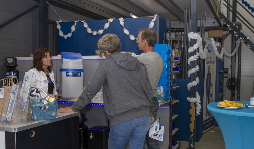 Geïnteresseerde bezoekers laten zich informeren over water-ontharders door één van de aanwezige adviseurs van Mezutec.