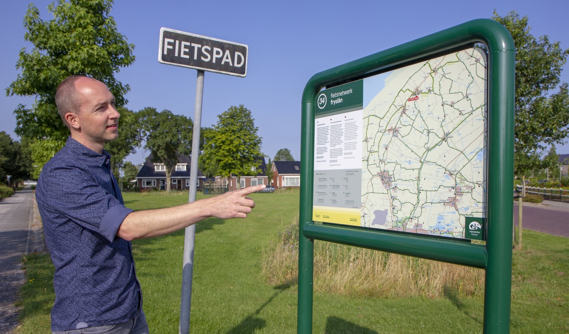 Michiel Bakema van recreatieschap Marrekrite bij een bord van het fietsknooppuntnetwerk in Fryslân.