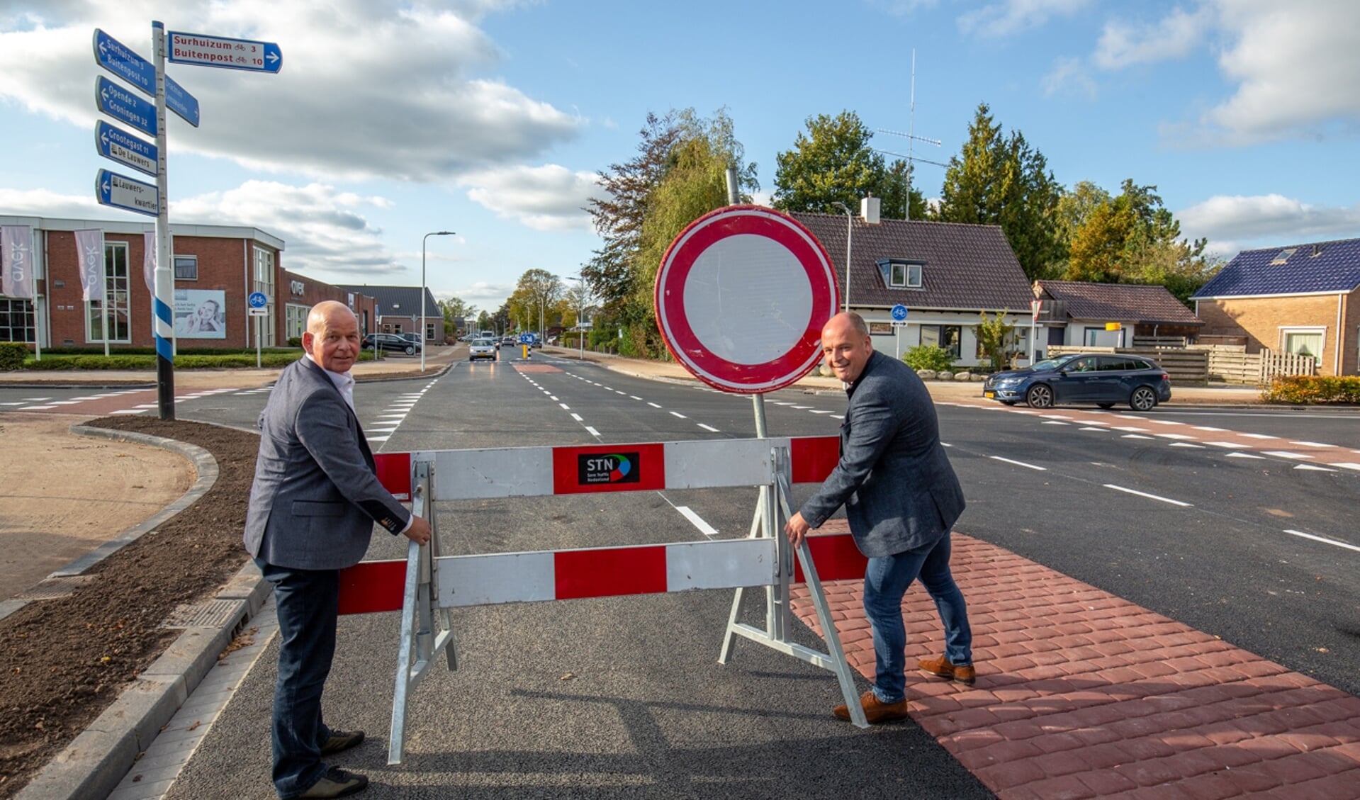 Wethouder Max de Haan van de gemeente Achtkarspelen  en Hidde Witteveen van aannemer Witteveen geven de weg eerder vrij dan gepland.