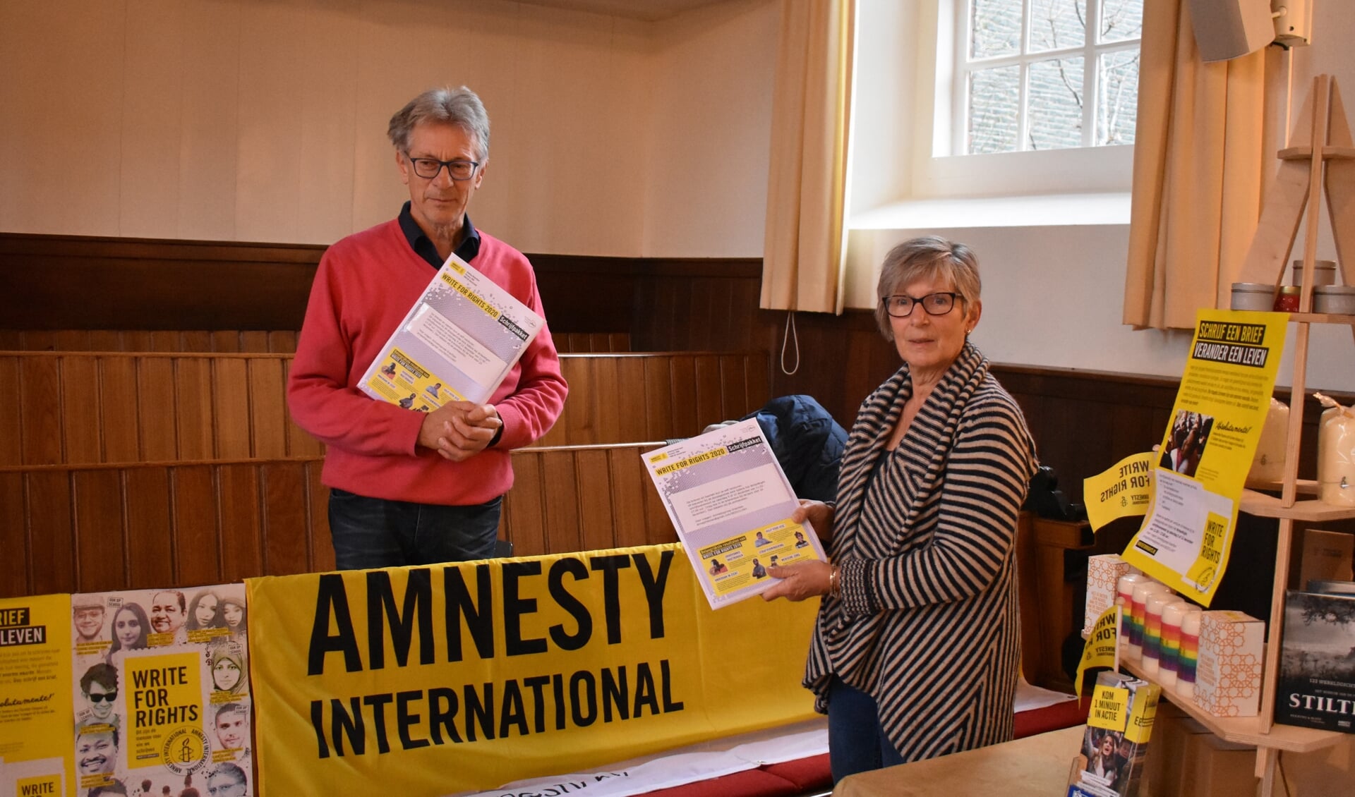 Jehannes en Anna Regnerus in december bij de kraam van Amnesty International met schrijfpakketten in de Doopsgezinde kerk in Drachten.