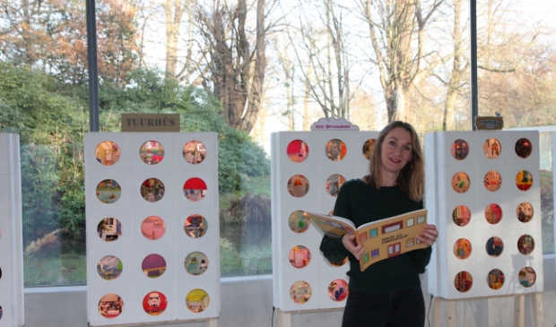 Mariese Schuurman van 'Stoereloer' bij de miniatuurflats, met het bijbehorende boek, in paviljoen Vijversburg.