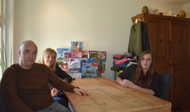 Hans de Kok, Brenda Terluin en Adriana Perdok (v.l.n.r.). Achter hen te verdelen spellen en kleren.