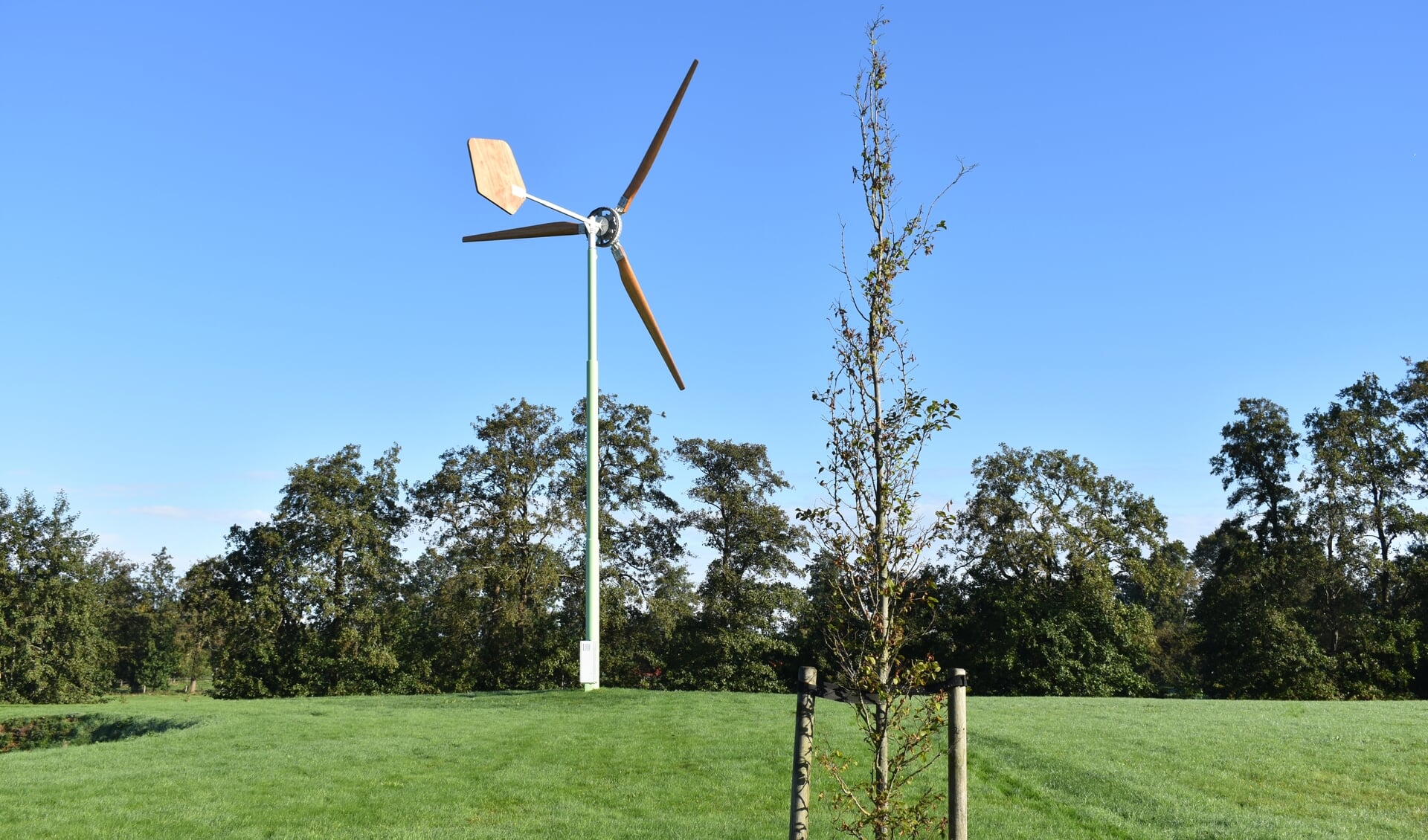 Een voorbeeld van een kleine windturbine, met houten wieken en windblad.