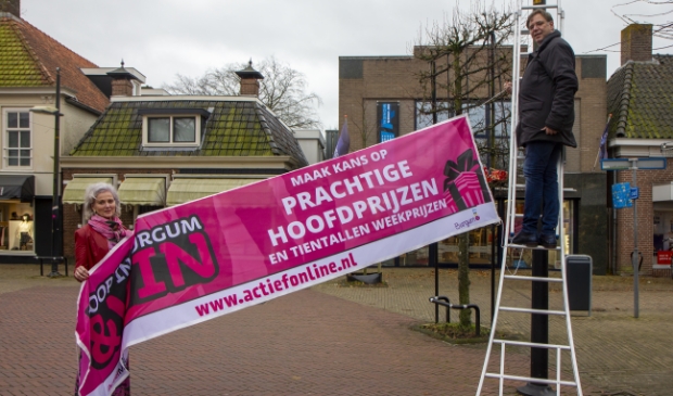 <p>Marion Brink (BAK) en Jan Auke Steegstra (Actief Media) hangen een spandoek op voor de actie. </p>