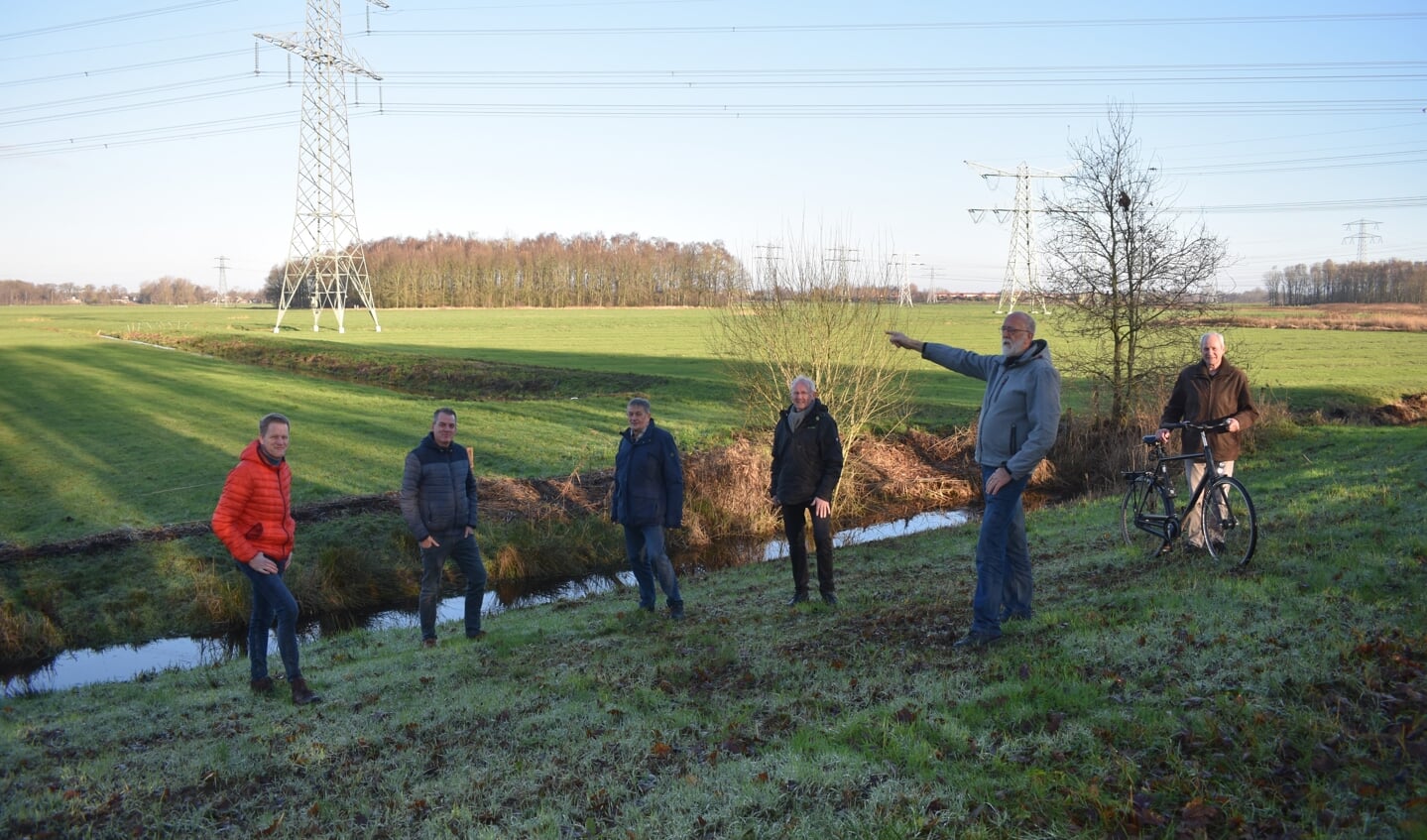 Zes van de tien leden van de Energiecoöperatie Burgum voor het weiland waar ze - tot de bomen op de achtergrond - zonnepanelen willen plaatsen.