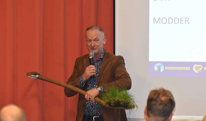 Theo Mulder houdt een graszode omhoog: "Er zit meer leven in dan er mensen op aarde zijn."