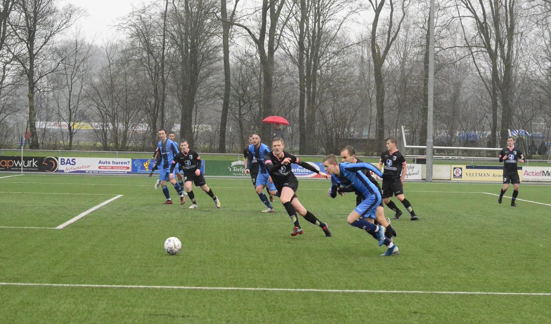 Harmen Vlietstra van FC Burgum (vooraan, blauw tenue) snelt langs een aantal tegenstanders van Be Quick Dokkum.