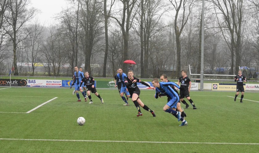 Harmen Vlietstra van FC Burgum (vooraan, blauw tenue) snelt langs een aantal tegenstanders van Be Quick Dokkum.