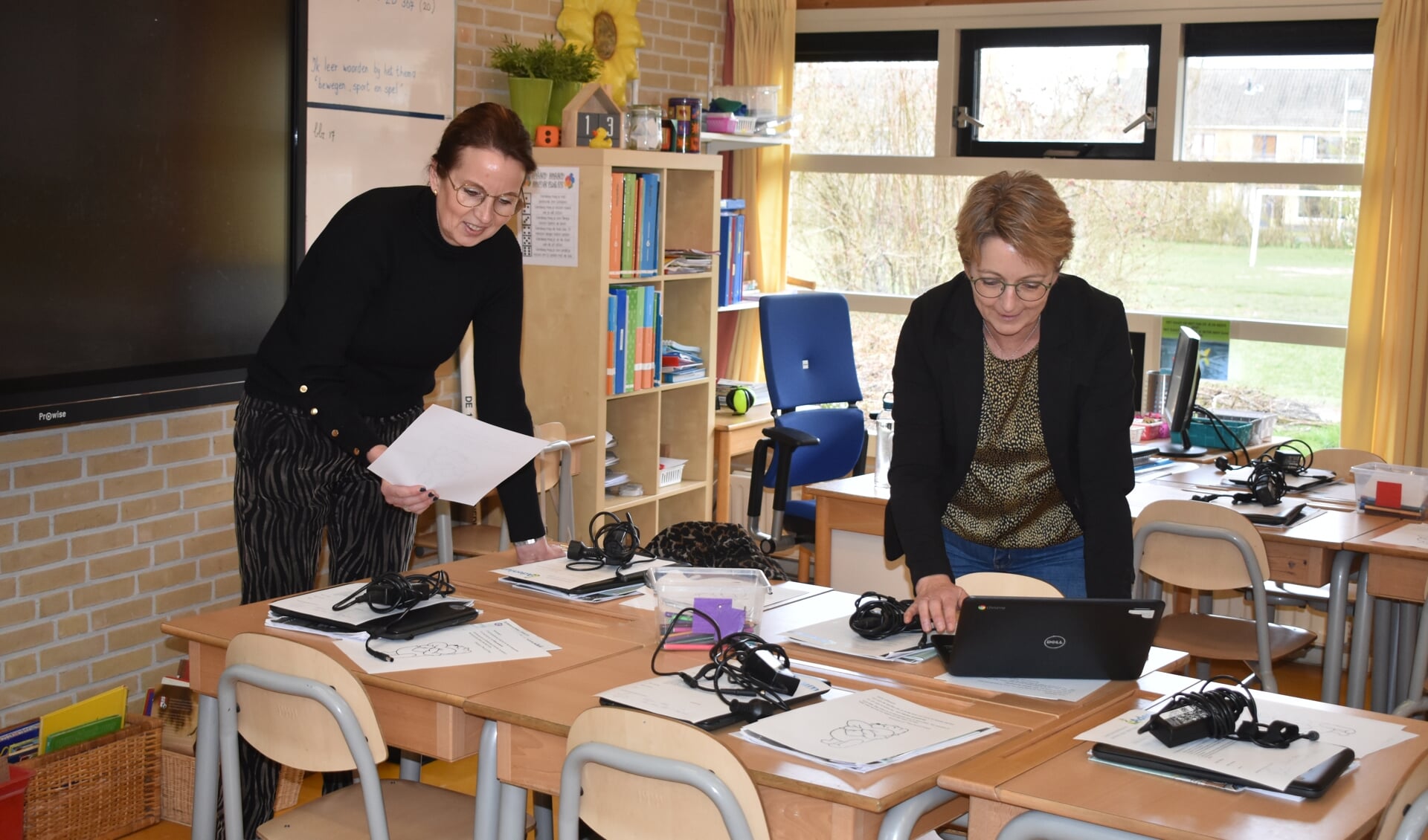 Fokje de Roos (links) en Thea van der Werff zetten de Chromebooks klaar voor leerlingen van groep 6 van 't Partoer.