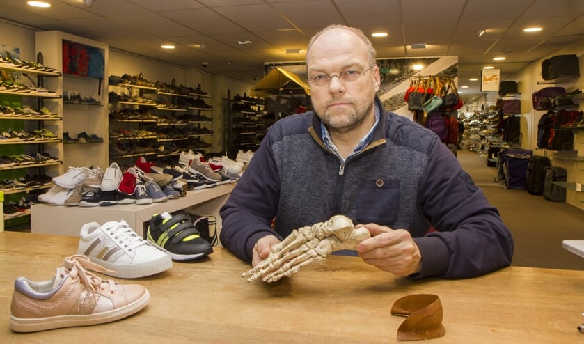 Sjoerd Lampers demonstreert welke beweging een voet wel en niet maakt. Op tafel een contrefort en góede kinderschoenen.