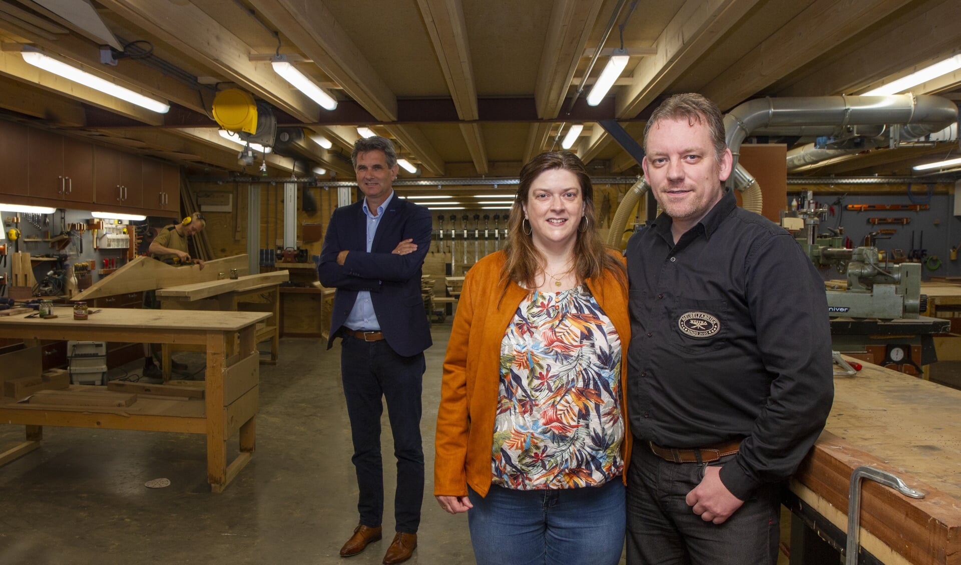 Sandra en Feiko Westra in hun meubelfabriek in Burgum. Op de achtergrond bedrijfsadviseur Jan Tabak van Apuls Cijfers & Advies.