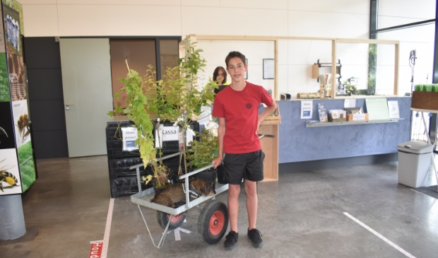 Victor uit Amsterdam koopt, samen met z'n hondje, planten in de Kruidhof-winkel.
