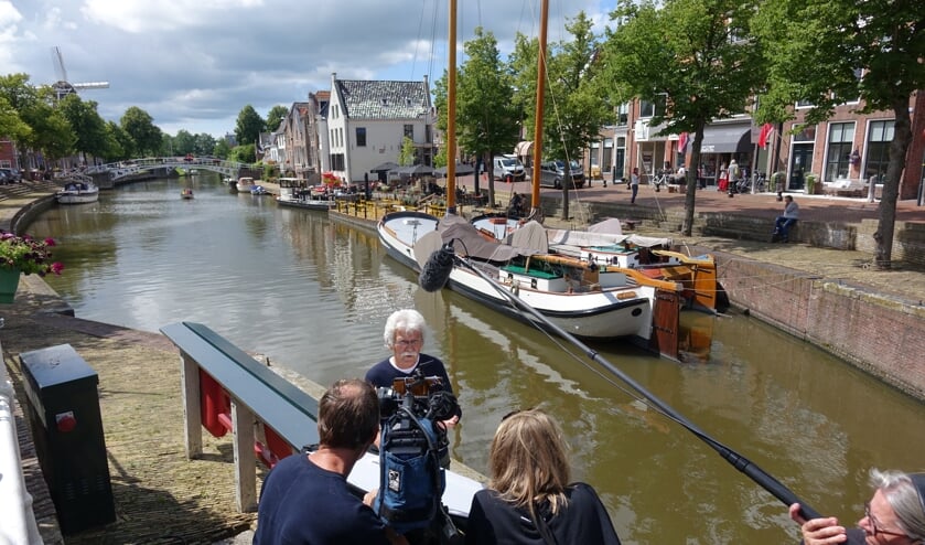 Sytse van der Werf wordt geïnterviewd. Op de achtergrond het wedstrijdskûtsje van Dokkum.