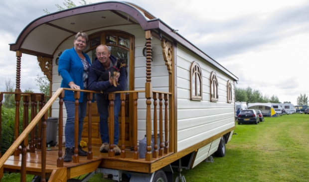 Jolanda en Ed Boonzaaijer op het bordes van hun zelfgebouwde pipowagen.