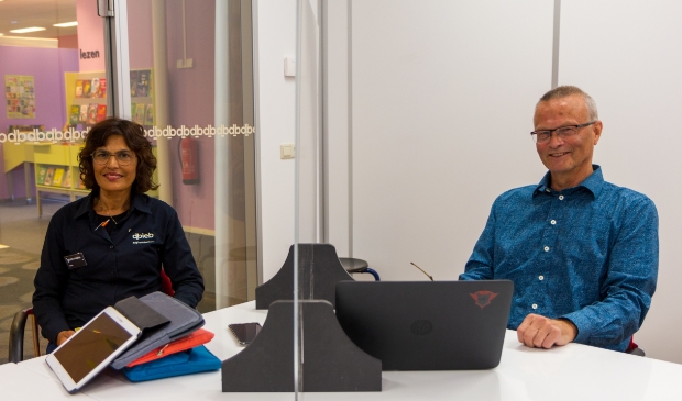 Sita van der Velde, gastvrouw van dbieb en Ton Pingen van Seniorweb Burgum demonstreren hoe de inloopmiddagen met inachtneming van de coronamaatregelen gaan verlopen.