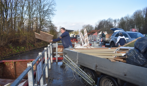 Jan Spinder uit Drogeham gooit afvalhout weg. Op de achtergrond legen Fokko en Boukje Luchtenburg uit Augustinusga een aanhangwagen bouwafval.