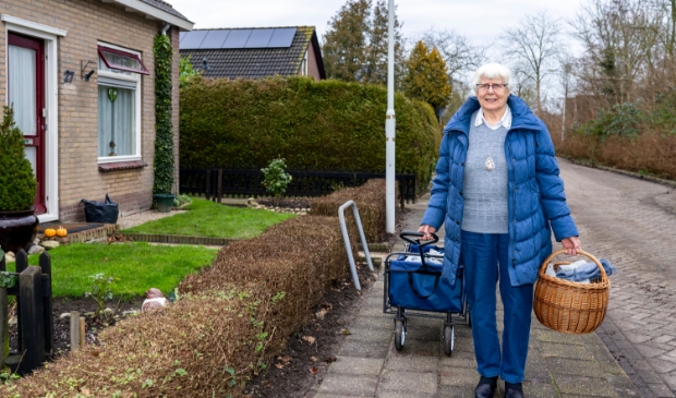 <p>Jos Holman, hier bij haar woning aan de Fjildwei 27 in Jistrum, legt haar zelfgebreide sokken geregeld in de bolderkar op zoek naar liefhebbers.</p>