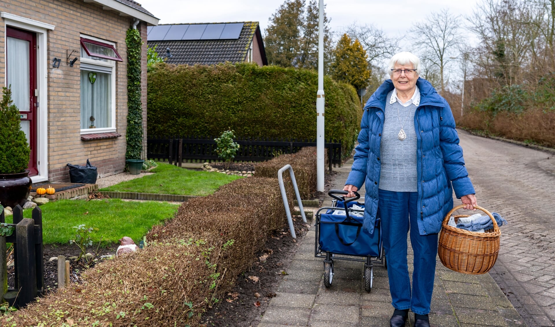 Jos Holman, hier bij haar woning aan de Fjildwei 27 in Jistrum, legt haar zelfgebreide sokken geregeld in de bolderkar op zoek naar liefhebbers.