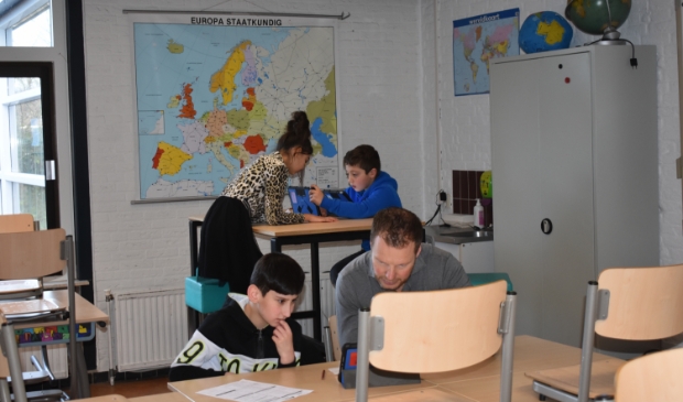 Drie kinderen uit de groepen 6 en 7 (Milad, linksvoor, Amal en Paulo) en meester Pieter Visser.
