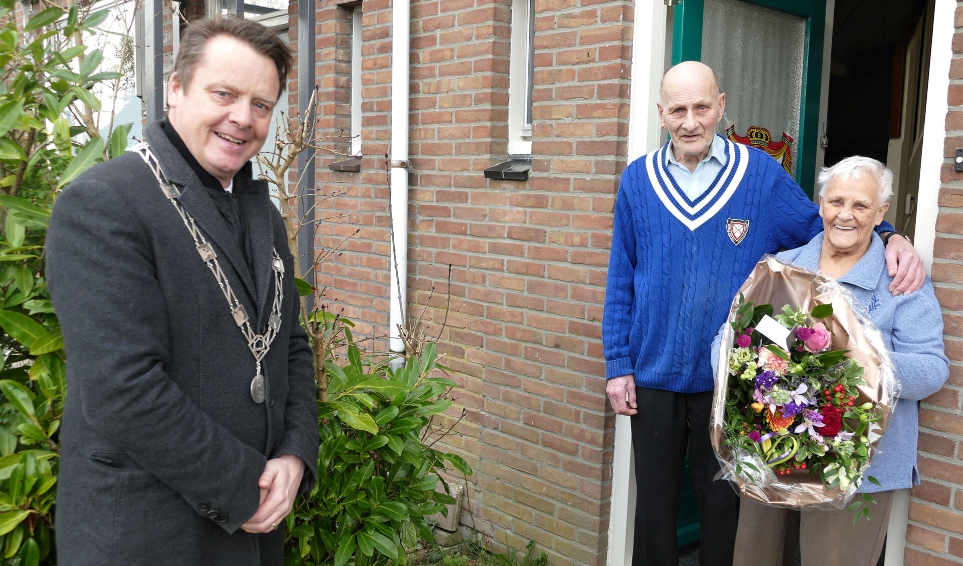 Burgemeester Johannes Kramer brengt een bloemetje en de felicitaties bij het jubilerende echtpaar Jelle en Jansje Boorsma.