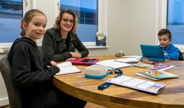 <p>Terwijl Jente de online les volgt bij zijn meester, maakt zus Silke samen met moeder Klazina de overstap van het half uur stillezen naar het rekenwerk op de tablet. Midden op tafel ligt de map met de weekplanning.</p>