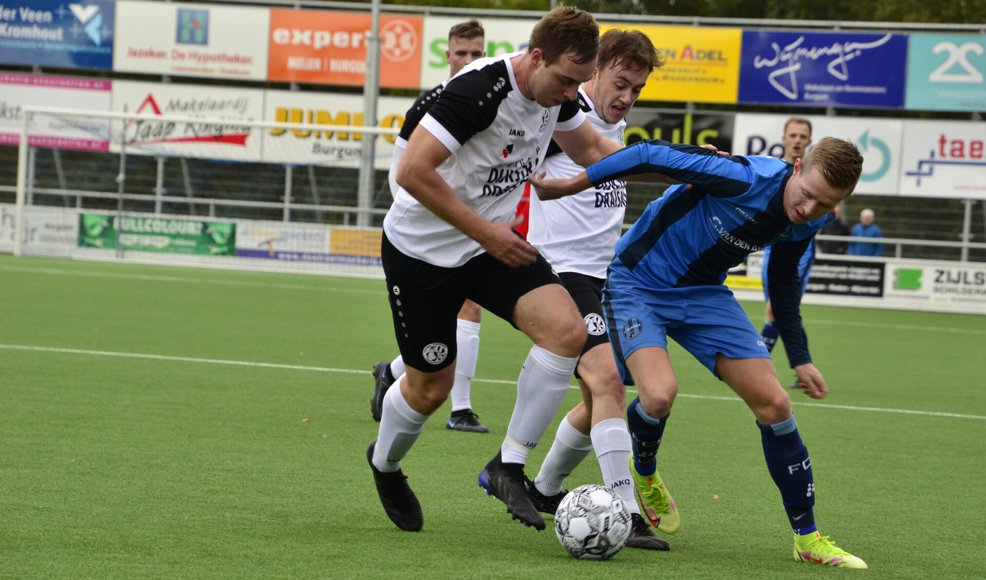 Harmen Vlietstra van FC Burgum in een fel duel met de verdediging van Drachtster Boys. 