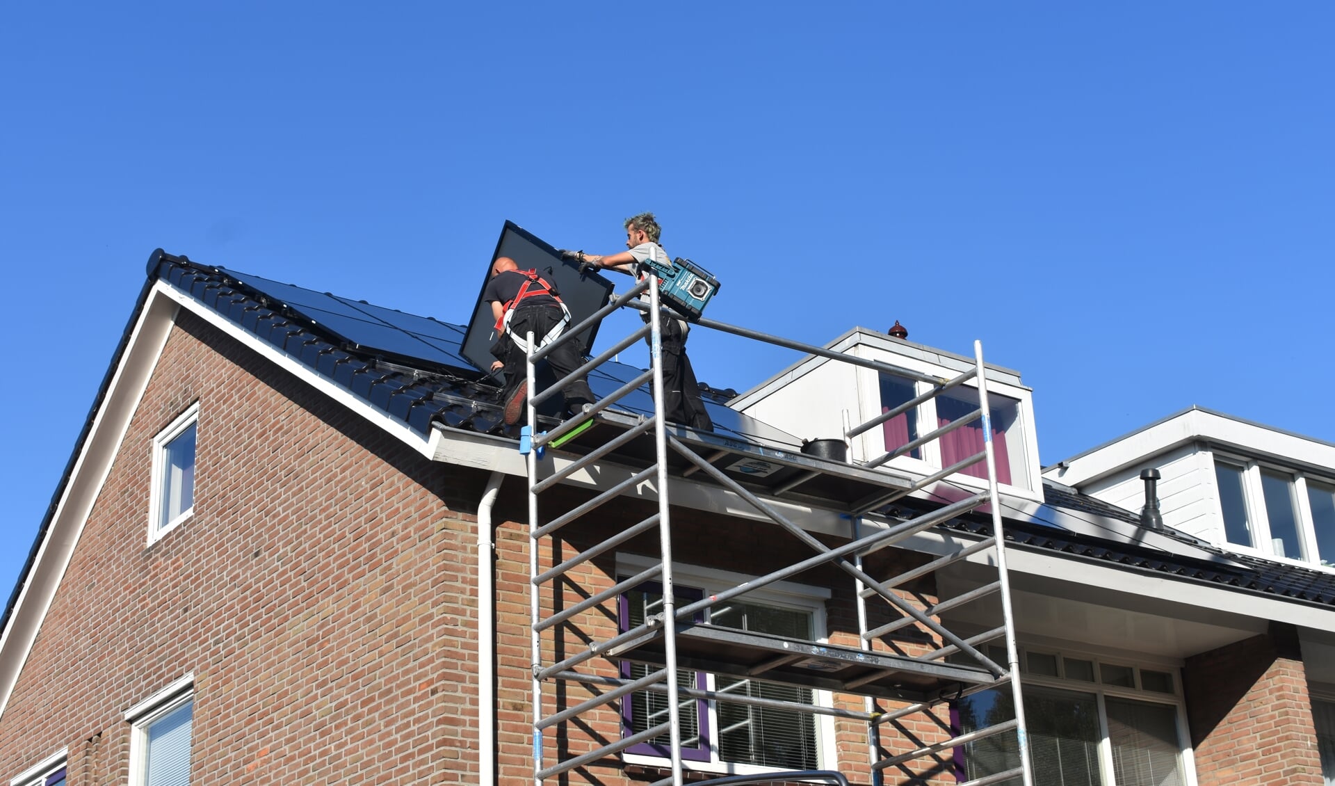 Medewerkers van Solar-Systemen.nl in Drachten leggen twintig zonnepanelen op het dak van een woning aan de Gauke Boelensstraat in Drachten. Het is één van de manieren om het reguliere stroomverbruik flink te beperken.