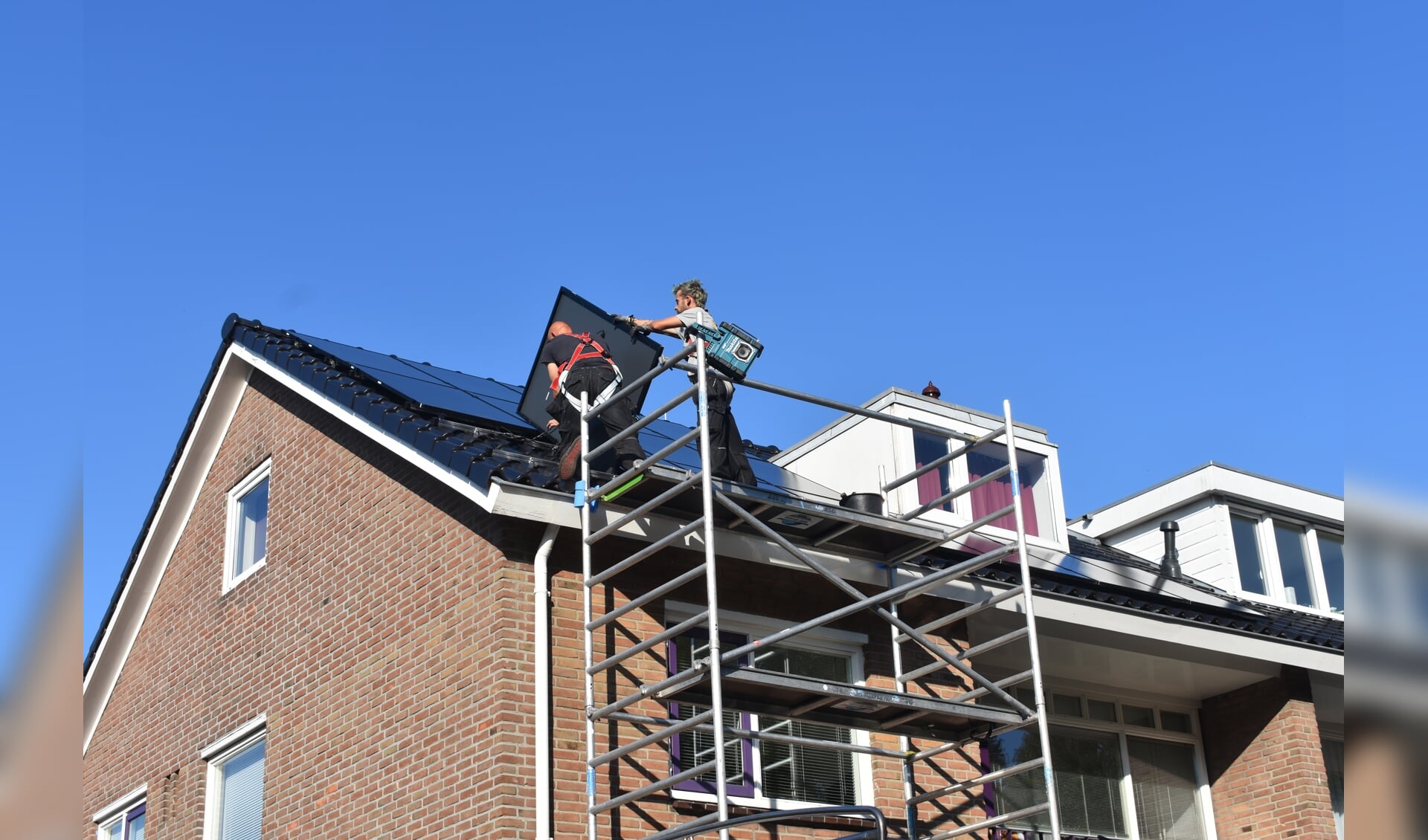 Medewerkers van Solar-Systemen.nl in Drachten leggen twintig zonnepanelen op het dak van een woning aan de Gauke Boelensstraat in Drachten.