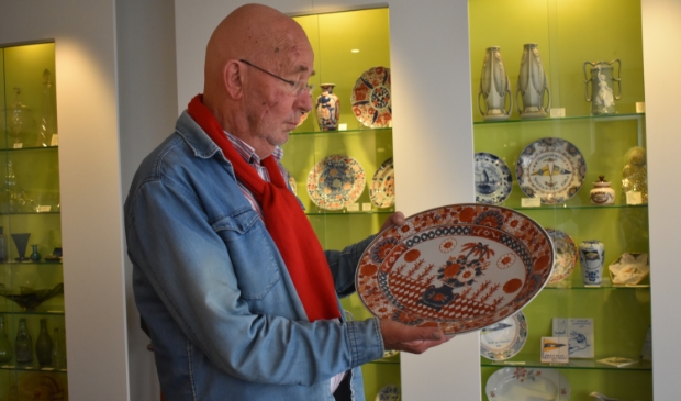<p>Klaas Henstra toont in zijn antiekwinkel een bord van Japanse makelij.</p> 