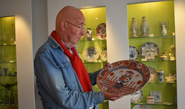 Klaas Henstra toont in zijn antiekwinkel een bord van Japanse makelij.